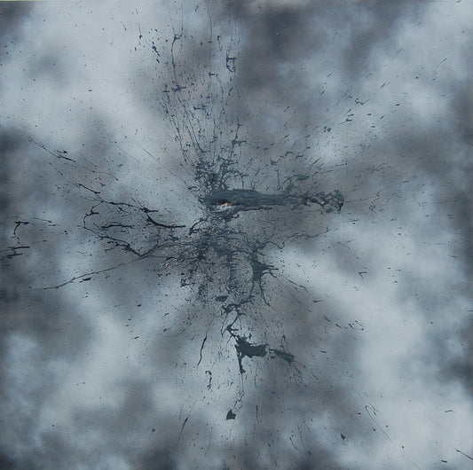 A black mark applied with a shotgun on a sprayed grey and white background.