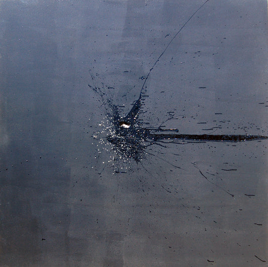 A black mark applied with a shotgun on a dark grey background.